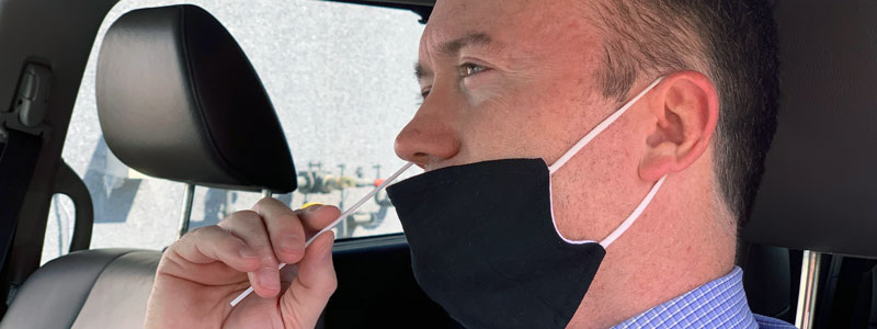 Man doing a self-administered nasal swab to test for COVID-19.